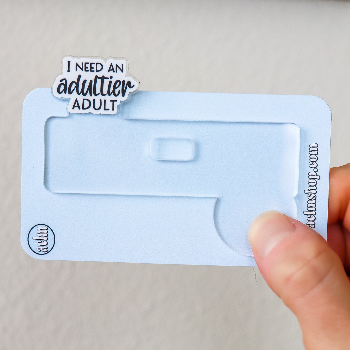 Badge Topper - I Need An Adultier Adult - Acclaim Status Co Acclaim Status Co Black Font