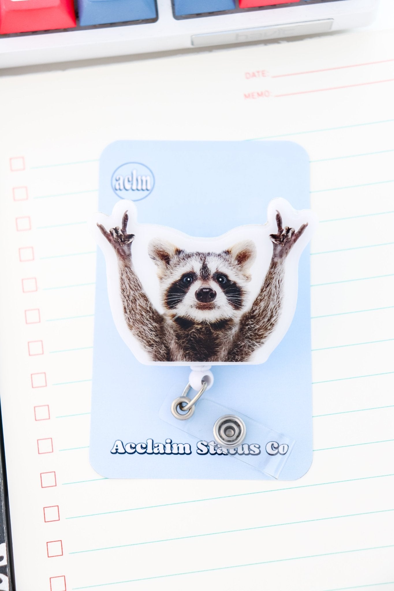 Badge Reel - Raccoon Hands Up - Acclaim Status CoAcclaim Status CoAlligator Clip