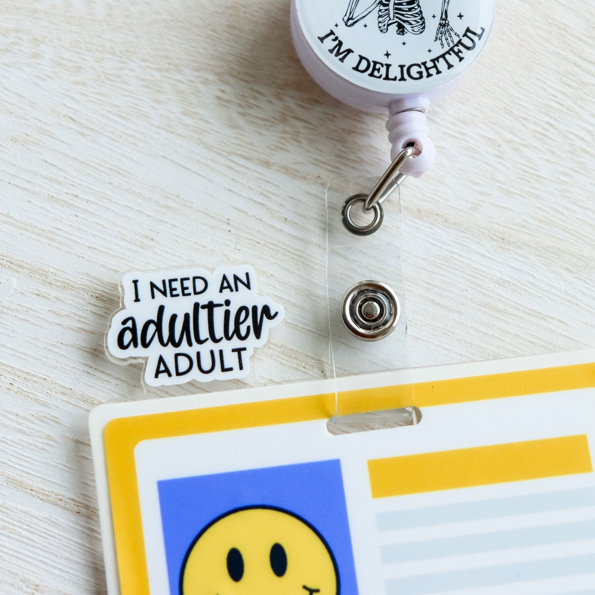 Badge Topper - I Need An Adultier Adult - Acclaim Status Co Acclaim Status Co Black Font